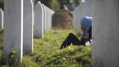 Una chica llora junto a la tumba de un familiar en el Centro memorial de Srebrenica, Bosnia-Herzegovina, hoy, 11 de julio. EFE