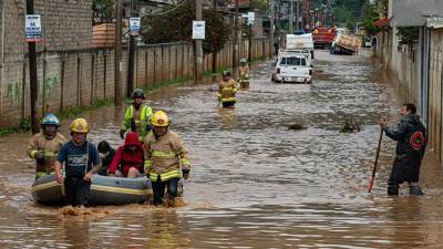 Personal de bomberos rescatan a una familia de la zona inundada el 8 de junio de 2022, en el municipio de San Cristobal de las Casas, Chiapas (México).