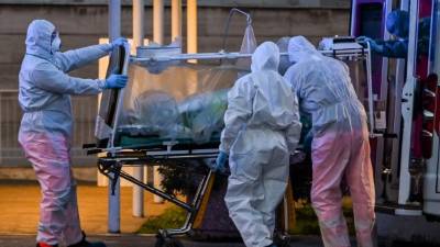 Medical workers in overalls stretch a patient under intensive care into the newly built Columbus Covid 2 temporary hospital to fight the new coronavirus infection, on March 16, 2020 at the Gemelli hospital in Rome. (Photo by ANDREAS SOLARO / AFP)