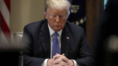 El presidente de Estados Unidos, Donald Trump, inclina la cabeza mientras reza durante una reunión con los pastores del centro de la ciudad. EFE/foto de archivo.