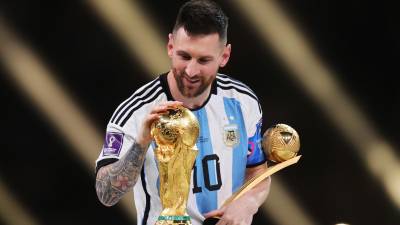 Lionel Messi toca el trofeo de la Copa del Mundo después de ganar el premio del balón de oro durante la ceremonia de entrega de premios tras la final de la Copa Mundial de Qatar 2022 entre Argentina y Francia.