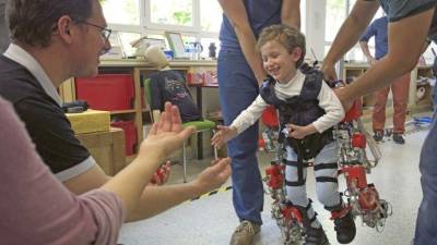 Álvaro, de cinco años y afectado por atrofia muscular espinal, prueba el exoesqueleto del CSIC.