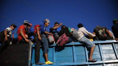 Honduran migrants heading in a caravan to the US, board a truck in Metapa on their way to Tapachula, Chiapas state, Mexico on October 22, 2018. - President Donald Trump on Monday called the migrant caravan heading toward the US-Mexico border a national emergency, saying he has alerted the US border patrol and military. (Photo by AFP)