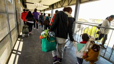 TJN01. EL CHAPARRAL (MÉXICO), 04/05/2018.- Migrantes centroamericanos cruzan hacia Estados Unidos hoy, viernes 4 de mayo de 2018, desde la línea ubicada en la ciudad del El Chaparral, en la fronteriza Tijuana (México). La Oficina de Aduanas y Protección Fronteriza (CBP) de EE.UU. continúa recibiendo solicitudes de asilo de integrantes de la caravana de migrantes, cuya mayoría permanece a la intemperie en el cruce entre Tijuana (México) y San Diego (California) a la espera de que su petición sea estudiada. EFE/Joebeth Terriquez