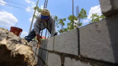 Un hombre trabaja en la edificación de casas.