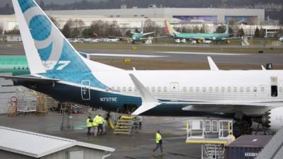 Trabajadores son fotografiados junto a un avión Boeing 737 MAX 9 en la pista en la fábrica de Boeing Renton en Renton, Washington. AFP