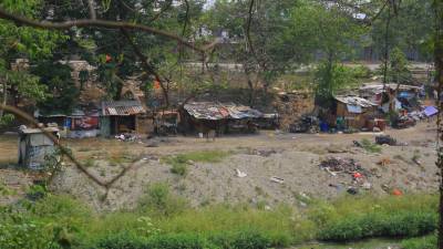 <b>Familias han hecho casas de madera, plástico y zinc en el bordo que queda frente a la Cámara de Comercio de Cortés. Fotos: Melvin Cubas y Héctor Edú.</b>