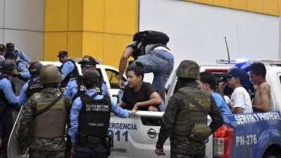 TG7001. SAN PEDRO SULA (HONDURAS), 01/12/2017.- Miembros de la policía detienen a un grupo de ciudadanos presuntamente capturados durante el saqueo de diferentes centros comerciales hoy, viernes 1 de diciembre de 2017, en la ciudad de San Pedro Sula (Honduras). Honduras vive un ambiente de máxima tensión por la violencia desatada desde el miércoles con protestas en las calles, a pocas horas de que se conozca al nuevo presidente electo de los comicios generales del domingo, en los que los dos principales candidatos se autoproclamaron como tal. EFE/Jose Valle