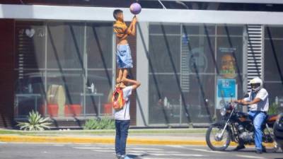 Dos niños hacen malabares bajo un semáforo en Tegucigalpa (Honduras). EFE