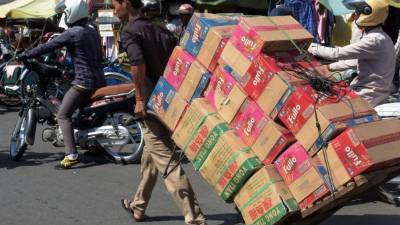 Un hombre transporta productos en una calle de Phnom Penh, capital de Camboya, que es uno de los países menos desarrollados en la región de Asean.