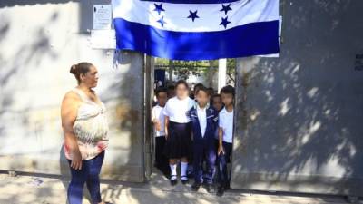 La presidenta de la asociación de padres del CEB Edmon Bográn junto con un grupo de alumnos a la entrada del centro.