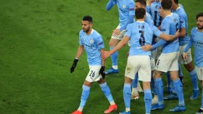 Manchester City's Algerian midfielder Riyad Mahrez (L) celebrates scoring the 1-1 goal from the penalty spot with his team-mates during the UEFA Champions League quarter-final second leg football match between BVB Borussia Dortmund and Manchester City in Dortmund, western Germany, on April 14, 2021. (Photo by WOLFGANG RATTAY / various sources / AFP)