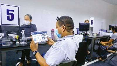 Un ciudadano observa la nueva placa que acaba de recibir de empleados del IP. Fotos: Moisés V.