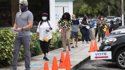 MIAMI, FLORIDA - OCTOBER 19: Voters wait in line, socially distanced from each other, to cast their early ballots at the Lemon City Branch Library precinct on October 19, 2020 in Miami, Florida. The early voting ends on Nov. 1. Voters are casting their ballots for presidential candidates President Donald Trump and Democratic presidential nominee Joe Biden. Joe Raedle/Getty Images/AFP