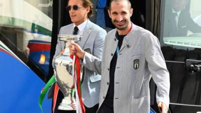 Giorgio Chiellini y el entrenador Roberto Mancini cargando la Copa obtenida en Londres. Foto AFP.