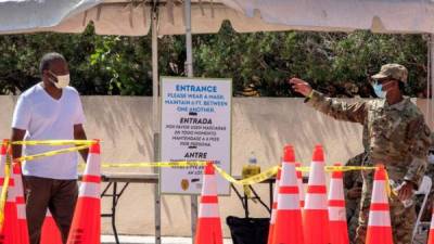 Un miembro de la Guardia Nacional de Florida da la instrucción de ingreso en el primer sitio de prueba sin cita previa en Miami-Dade. EFE