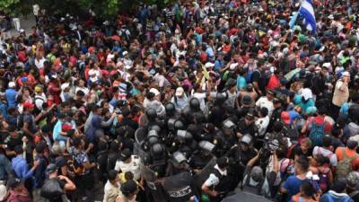Miles de migrantes hondureños que salieron en caravana superaron un bloqueo de policías y militares en la frontera guatemalteca de Tecún Umán y lograron su objetivo de cruzar a México, en su intento por llegar a Estados Unidos. Foto AFP