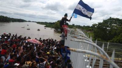 Cientos de migrantes hondureñas permanecen varados en uno de los puentes que atraviesa el río Suchiate, frontera natural entre Guatemala y México ayer viernes 19 de octubre de 2018, en Tecún Umán (Guatemala). EFE