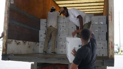 Los camiones destinados para la distribución de maletas en los municipios fueron cargados desde la mañana. Miembros del TSE y militares vigilan el proceso.