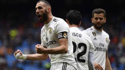 Real Madrid's French forward Karim Benzema (L) celebrates after scoring a goal during the Spanish league football match between Real Madrid CF and SD Eibar at the Santiago Bernabeu stadium in Madrid on April 6, 2019. (Photo by GABRIEL BOUYS / AFP)