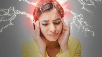 The young woman's portrait with pain emotions on gray background. Concept headache