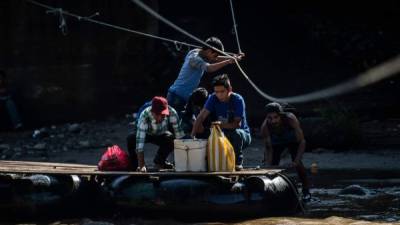 Un grupo de migrantes cruza la frontera entre México y Guatemala en una balsa a través del río Suchiate. Es este flujo migratorio el que el gobierno de Trump quiere que México detenga.