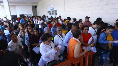Cientos de hondureños se forman en filas afuera del INM en San Pedro Sula. Fotos: M. Valenzuela