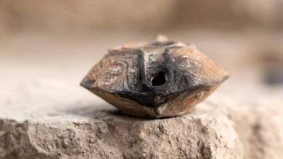 Fotografía facilitada por el Archivo Ciudad de David de un amuleto de arcilla hallado por arqueólogos israelíes que tiene una inscripción en árabe de hace unos mil años.EFE