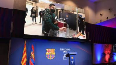 The image of Barcelona's Argentinian forward Lionel Messi voting for FC Barcelona presidential election is displayed at the Camp Nou stadium in Barcelona on March 07, 2021. (Photo by LLUIS GENE / AFP)