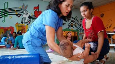 Una terapista atiende a un menor de edad en el centro de atención de San Pedro Sula.