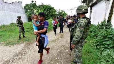 Militares y policías federales del suroriental estado de Tabasco custodiando el paso de un grupo de migrantes en Tenosique. EFE.