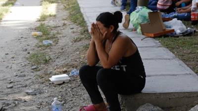 Una mujer llora mientras espera que le entreguen los restos de un familiar que murió en una masacre en el municipio de Choloma. En este hecho, una fémina perdió la vida, junto a 12 hombres más.