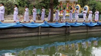 Aspirantes a novicias desfilan junto a un estanque en el monasterio Songdhammakalyani en Nakhon Pathom, provincia colindante con Bangkok. EFE