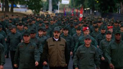 This handout picture released by Miraflores Palace press office shows Venezuela's President Nicolas Maduro (C) waving military troops accompanied by Defense Minister Vladimir Padrino (L) at the 'Fuerte Tiuna' in Caracas, Venezuela on May 2, 2019. - Maduro attends a 'march to reaffirm the absolute loyalty' of the Venezuelan Army, as opposition leader Juan Guaido continues making calls to oust his government. (Photo by HO / Presidency/JHONN ZERPA / AFP)
