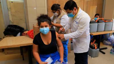 El viceministro de Salud, Roberto Cosenza, inyecta el biológico contra el covid-19 a una joven.