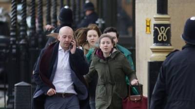 Testigos del ataque corren tras ser evacuados por la policia en el Parlamento de Londres.