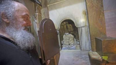 Un sacerdote franciscano en la entrada a la tumba de Jesucristo en la iglesia del Santo Sepulcro en la antigua ciudad de Jerusalén, Israel.