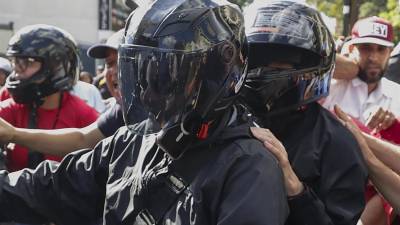 La líder antichavista María Corina Machado (d, casco negro) cuando se retira de una manifestación a bordo de una motocicleta el pasado jueves.