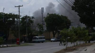 Una columna de humo, al parecer a causa de un incendio, se observa salir del Centro Penal Sampedrano en el marco del traslado de más de 600 reos este lunes.