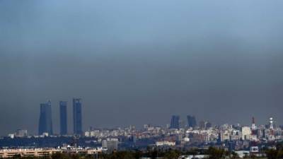 Vista de Madrid con el parque empresarial de las Cuatro Torres (i), en el Paseo de la Castellana de Madrid, y las Torres Kio (d), cubiertas por una 'boina' de contaminación. EFE/Archivo