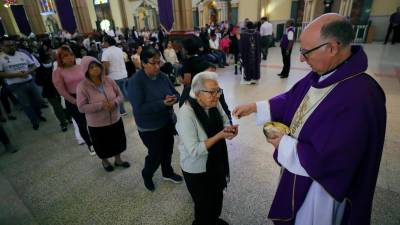El arzobispo de Tegucigalpa, José Vicente Nácher (d), entrega ostias a devotos católicos durante la misa en conmemoración del Miércoles de Ceniza, para dar inicio a la cuaresma previa a la Semana Santa, en la Basílica Menor de Suyapa en Tegucigalpa (Honduras).