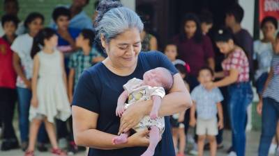 María Iris Ríos, presidenta de fundación Amor y Vida, carga a un recién nacido.