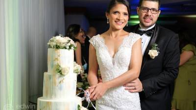 Enamorados. Evelin Funes y Nassim Gale parten el pastel de festejo de enlace nupcial.