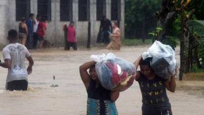 Local residents save their belongings at the Alemania suburb, which was flooded by the overflow of the La Arenera stream, due to the heavy rains caused by Hurricane Eta, now degraded to a tropical storm, in the city of El Progreso, department of Yoro, 260 kms north of Tegucigalpa, on November 4, 2020. - Hurricane Eta slowed to tropical storm speeds on Wednesday morning even as it pummeled Nicaragua, killing two people there and one in neighboring Honduras, while unleashing fierce winds and heavy downpours. (Photo by Orlando SIERRA / AFP)