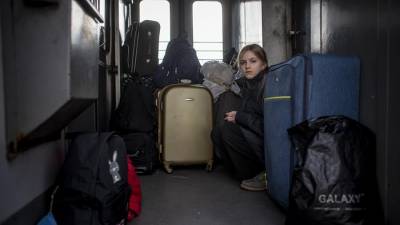 Una refugiada ucraniana se acomoda en un tren que parte de Ucrania a Polonia, en Mostyska.