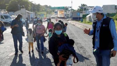 Varias personas cruzan la frontera de El Ceibo entre México y Guatemala. Fotografía: EFE.