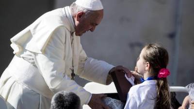 El papa Francisco saluda a una niña a su llegada a la audiencia general del papa en la plaza de San Pedro en el Vaticano, este miércoles. EFE
