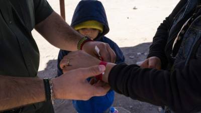 A mother and her son are given arm bands after turning themselves into US Border Patrol agents to claim asylum after crossing the Rio Grande in El Paso, Texas on March 19, 2019. - Speaking of an 'invasion' of illegal immigrants and criminals, US President Donald Trump last week signed the first veto of his presidency, overriding congressional opposition to secure emergency funding to build a wall on the Mexican border, the signature policy of his administration. (Photo by Paul RATJE / AFP)