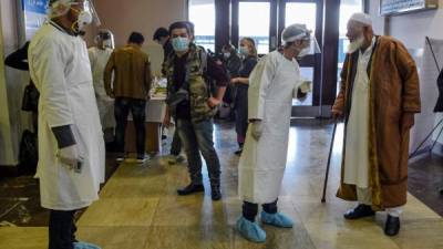 A nurse wearing protective mask and gear comforts another as they change shifts on March 13, 2020 at the Cremona hospital, southeast of Milan, Lombardy, during the country's lockdown aimed at stopping the spread of the COVID-19 (new coronavirus) pandemic. - After weeks of struggle, they're being hailed as heroes. But the Italian healthcare workers are exhausted from their war against the new coronavirus. (Photo by Paolo MIRANDA / AFP) / RESTRICTED TO EDITORIAL USE - MANDATORY CREDIT 'AFP PHOTO / PAOLO MIRANDA' - NO MARKETING - NO ADVERTISING CAMPAIGNS - DISTRIBUTED AS A SERVICE TO CLIENTS