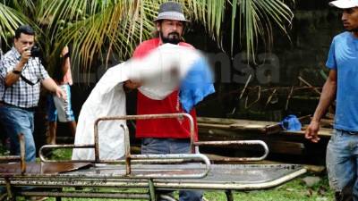 El cuerpo de Gerson Gámez Mejía, de 20 meses, es cargado por un poblador.